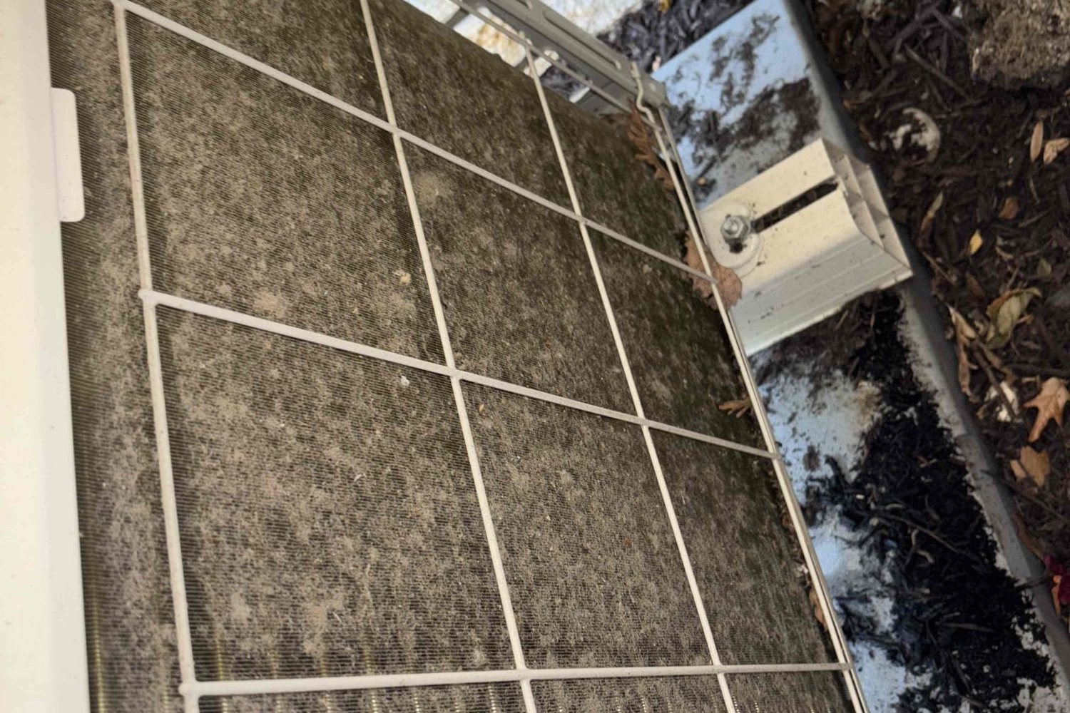 Mini-split outdoor condenser coil caked in dust and debris before cleaning